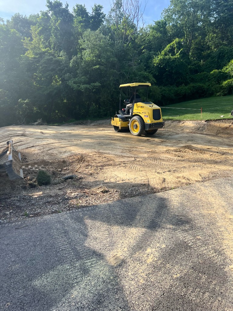 Roller compactor grading and leveling a residential building site